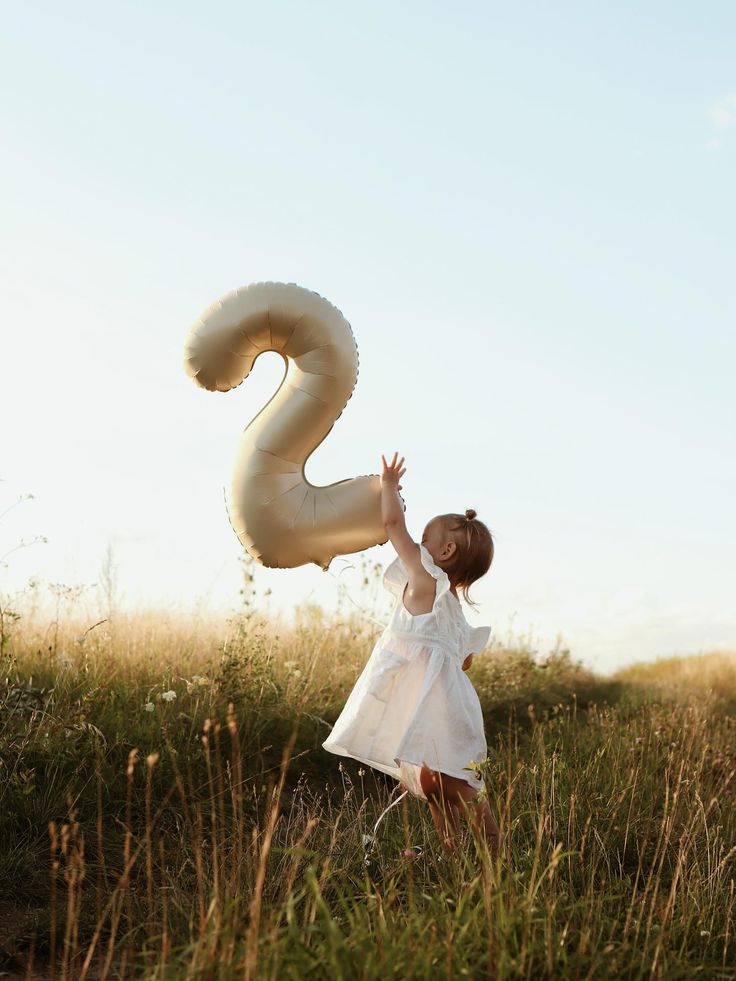 Photo d'une petite fille avec un ballon 2 ans dans les mains 