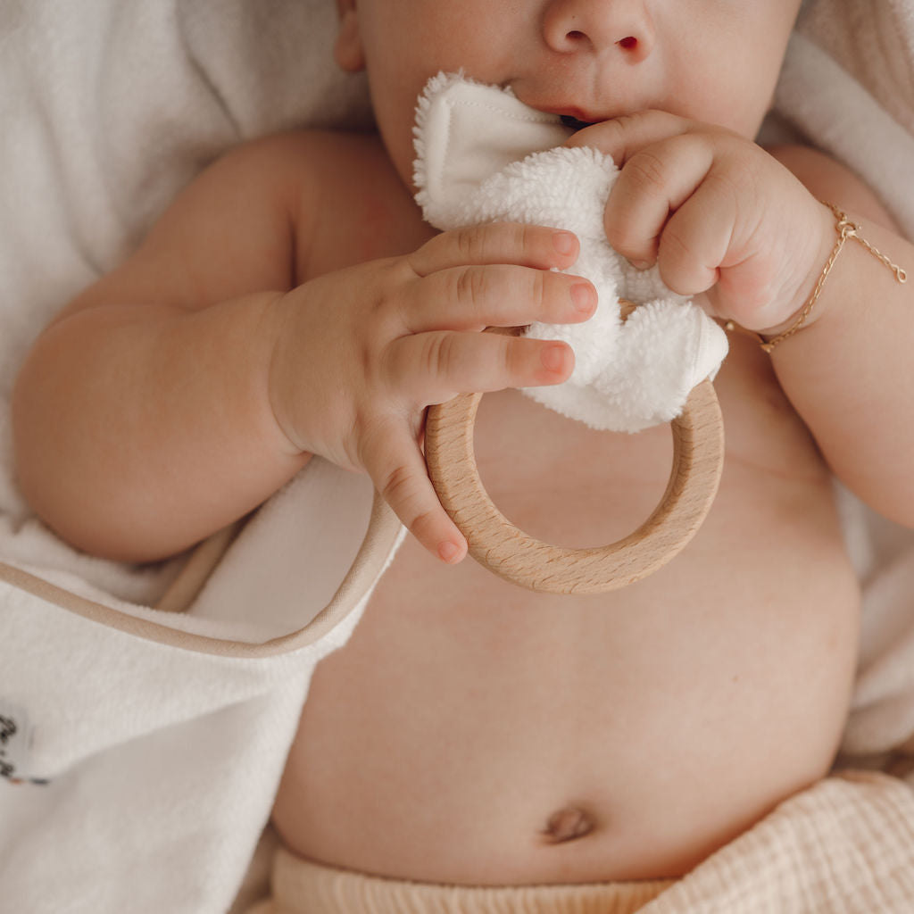 bébé qui tiens dans la main un hochet koala 