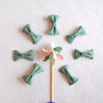 nœuds-papillon-en-tissu-vert-disposés -autour-d’un-moulin-a-vent-en-bois