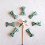 nœuds-papillon-en-tissu-vert-disposés -autour-d’un-moulin-a-vent-en-bois