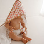 photo cape de bain love et hochet love porté par un bébé